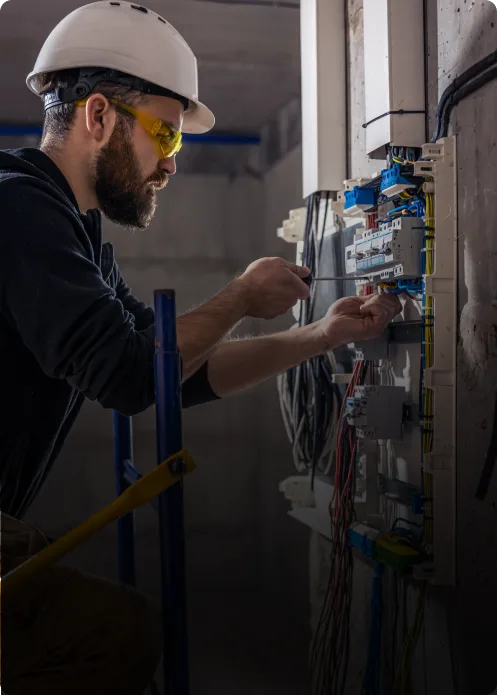 Electrician installing and testing an LV distribution board