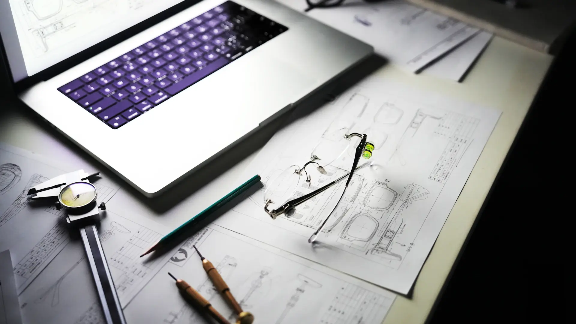 Drawings, tools and laptop on an engineer's desk
