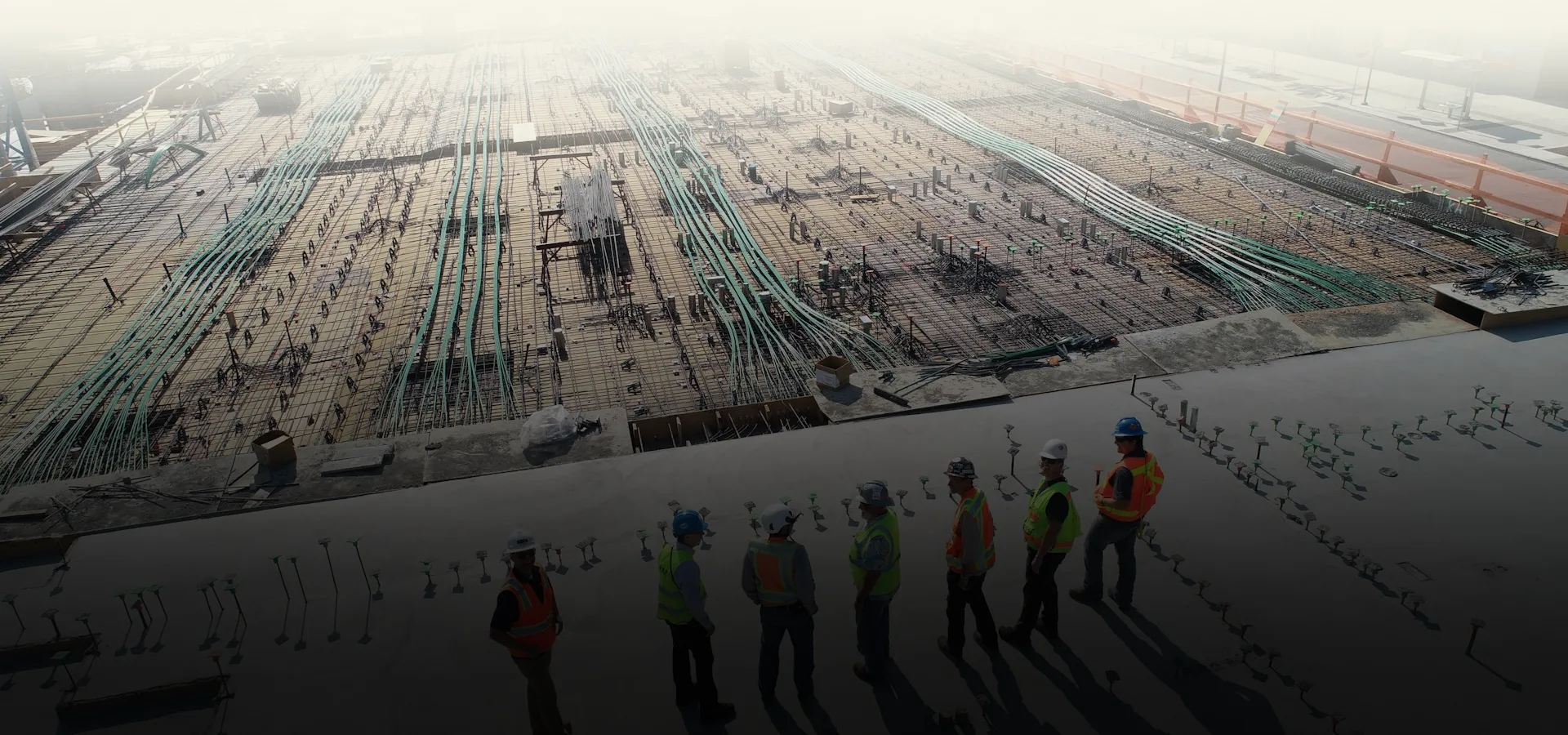 MEP workforce on a high-rise slab with laid conduits